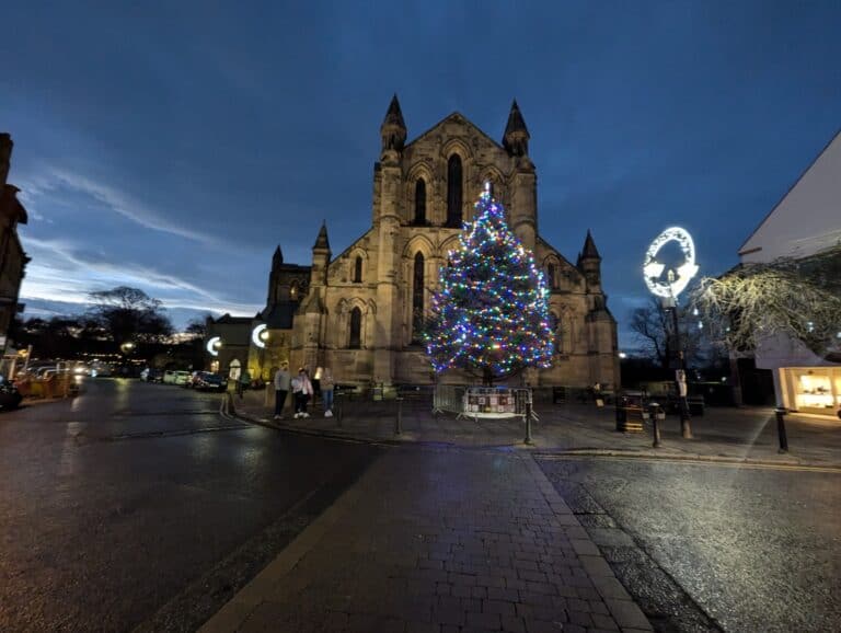 Hexham Abbey and the Market Place Christmas tree lit up at dusk