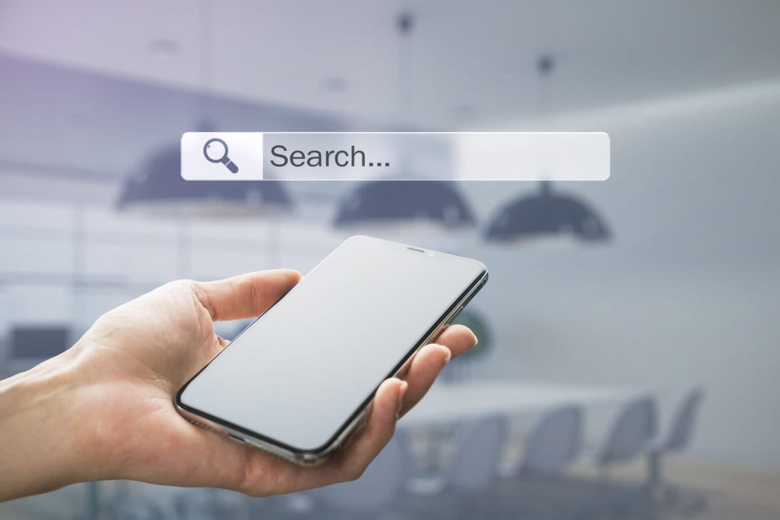 Hand holding a smartphone beneath a search bar, illustrating Google AI search
